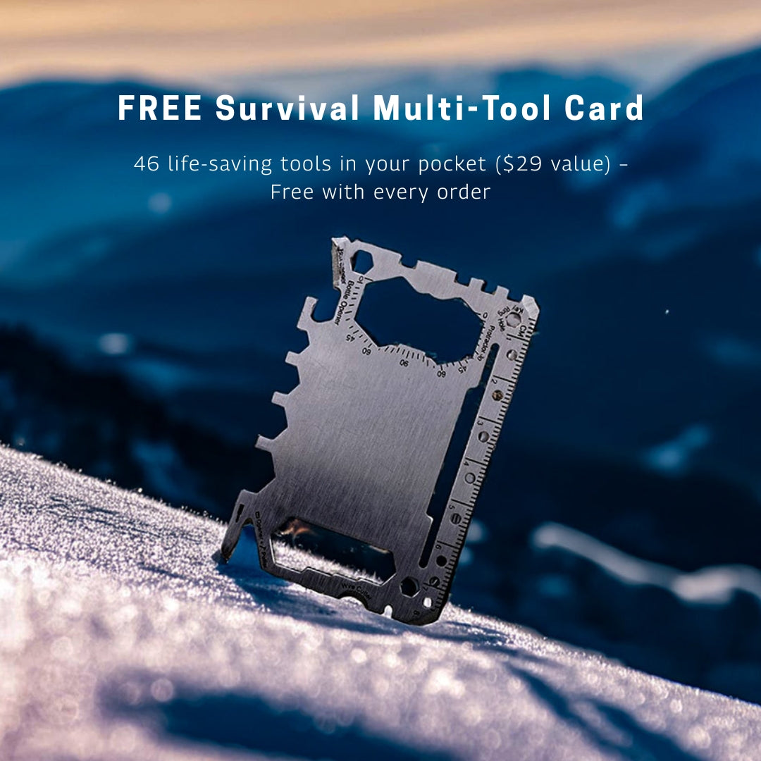 Stainless steel survival multi-tool card with 46 built-in functions, offered for free with every order, photographed in a snowy mountain setting.